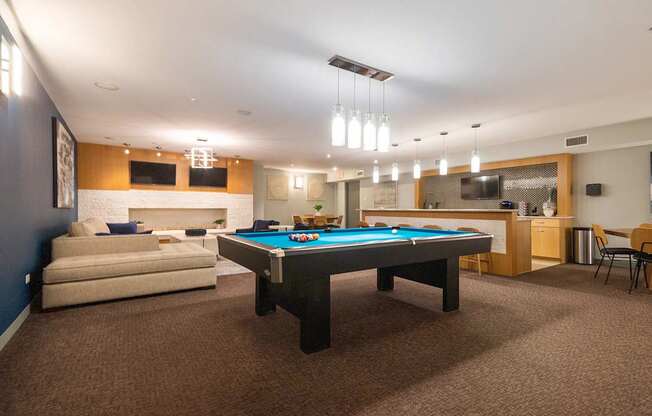 A room with a pool table and a couch.