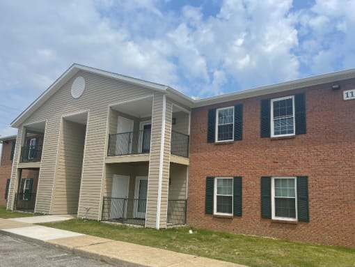 an apartment building with a brick exterior and white siding