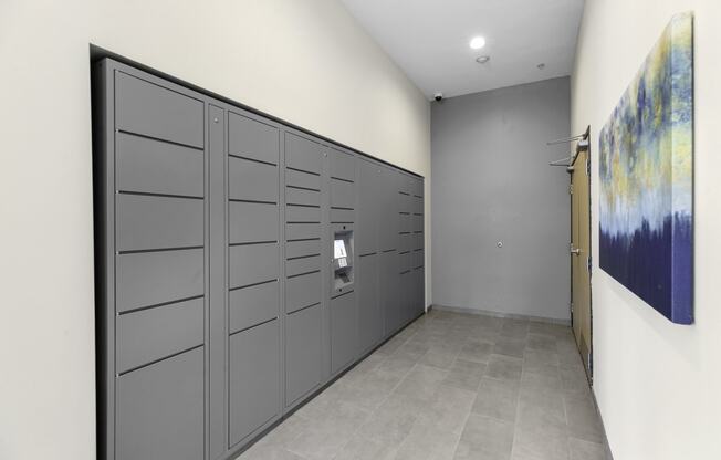 a row of package lockers with a painting on the wall at Arabella Apartment Homes, Shoreline