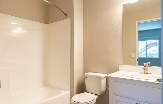 a bathroom with a toilet and a tub and a sink