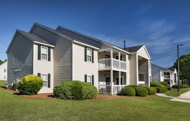 exterior view of three story residence with balconies and green grass