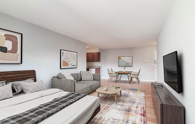 a bedroom with a bed and a couch in front of a tv