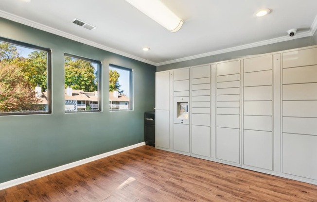 an empty room with white cabinets and a wood floor