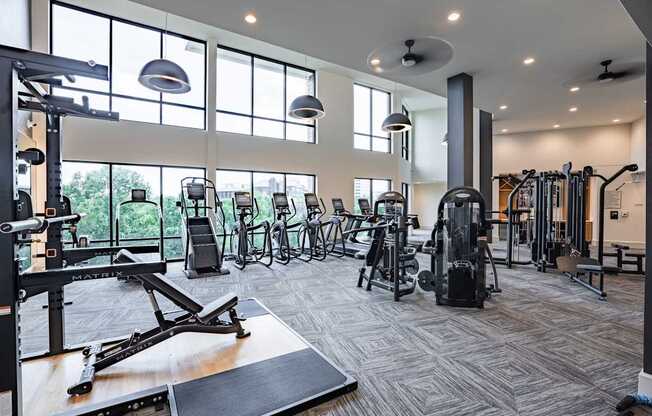 A gym with a variety of equipment including treadmills, weights, and exercise machines.