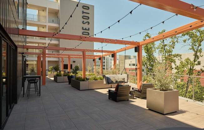 A patio area with a table and chairs under a pergola.