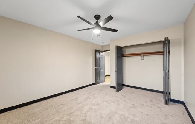 a empty living room with a ceiling fan and a garage door