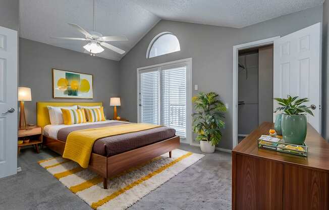 A bedroom with a bed, a ceiling fan, and a rug.