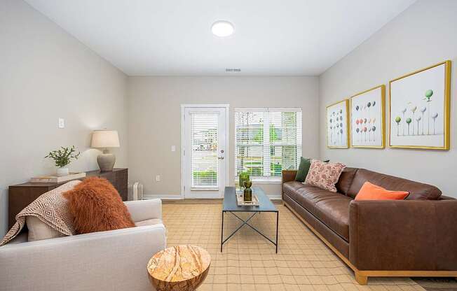 A living room with a brown couch, a white couch, and a coffee table.