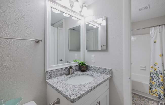 A bathroom with a sink, mirror, and toilet.