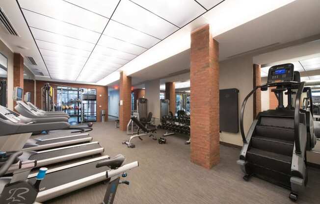 a gym with cardio equipment and weights in the lobby of a building