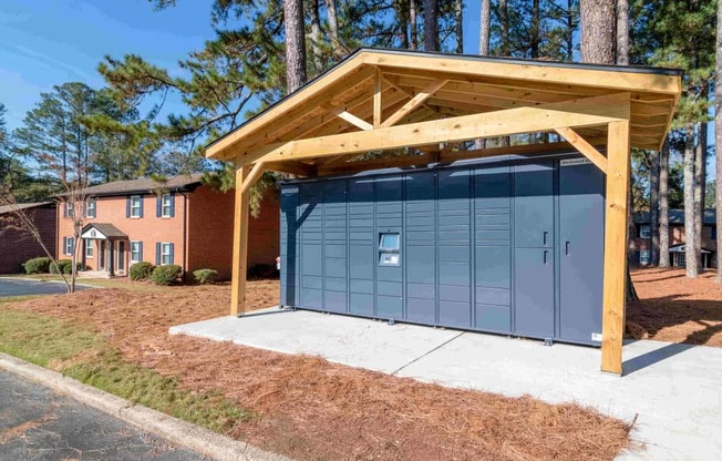 A small building with a blue door is covered by a wooden roof.