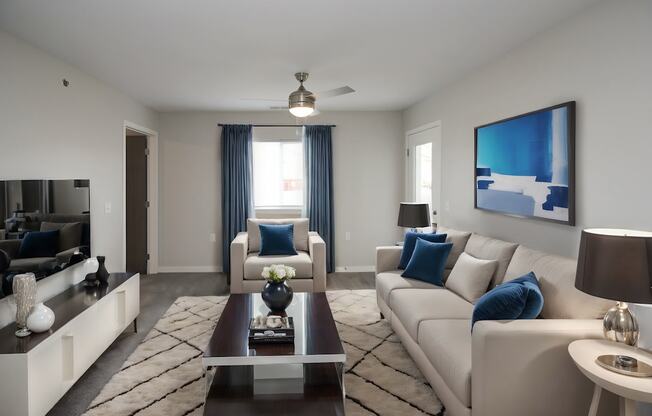 A modern living room with a large couch, a coffee table, and a painting on the wall.