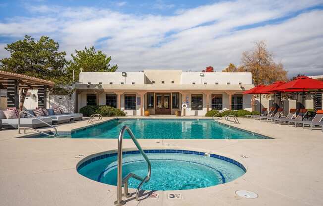 a swimming pool and spa in front of a house