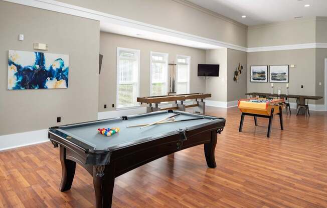 A pool table in a room with a bench and a television.