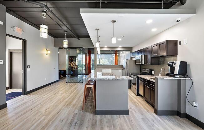 an open kitchen and living room with a large island at Troy Place Apartments - Troy, MI, Troy, Michigan