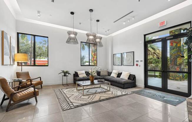 Lobby area with L sectional couch and designer lights at Bay Village 1 in Palmetto Bay, FL