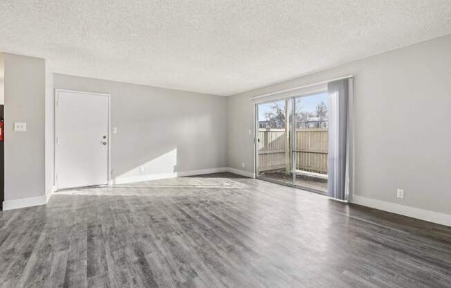 A spacious room with a grey floor and white walls.