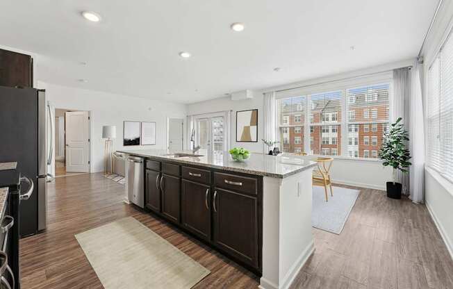 A kitchen with dark wood floors and white walls.