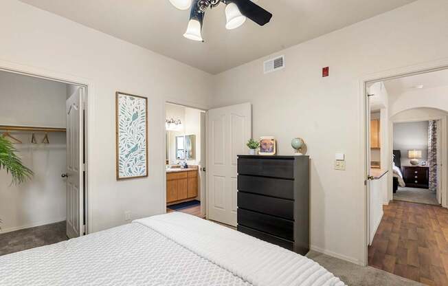 A bedroom with a large bed and a ceiling fan.