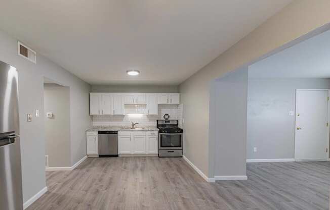 a kitchen with white cabinets and stainless steel appliances