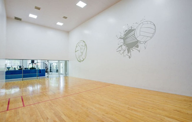a large room with a basketball court and paintings on the wall
