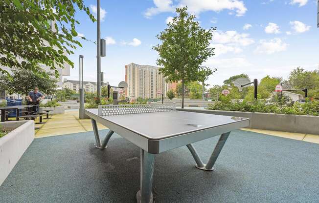 A man is playing ping pong in a park.