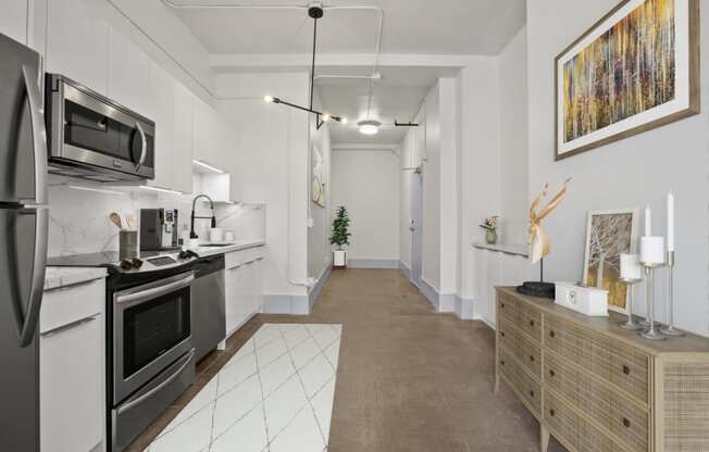 a kitchen with white cabinets and stainless steel appliances