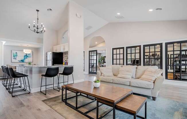 A modern living room with a bar area and a large window.