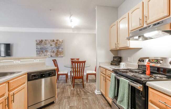 A kitchen with wooden cabinets and a stainless steel oven.