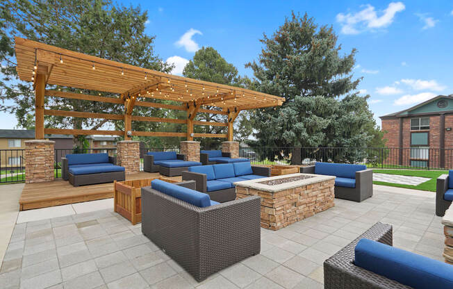 A patio with a wooden pergola and blue cushioned furniture at Mountain Vista Apartments, Colorado, 80228