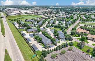A bird's eye view of a suburban area with a parking lot in the foreground.