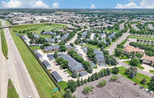 A bird's eye view of a suburban area with a parking lot in the foreground.