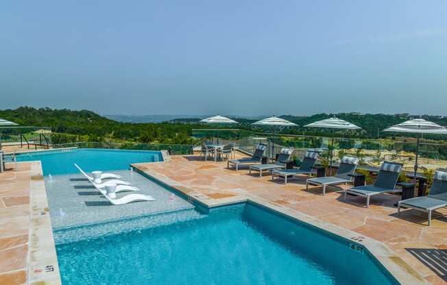 a swimming pool with chairs and umbrellas at a resort