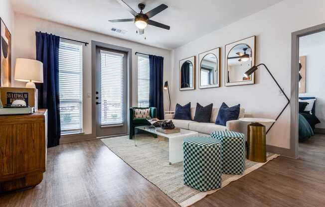A living room with a sofa, a coffee table, and a ceiling fan.