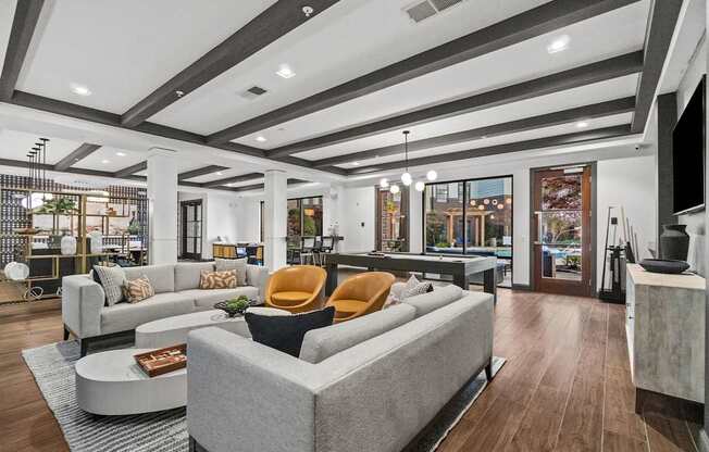 A modern clubroom with a grey sofa and a coffee table.
