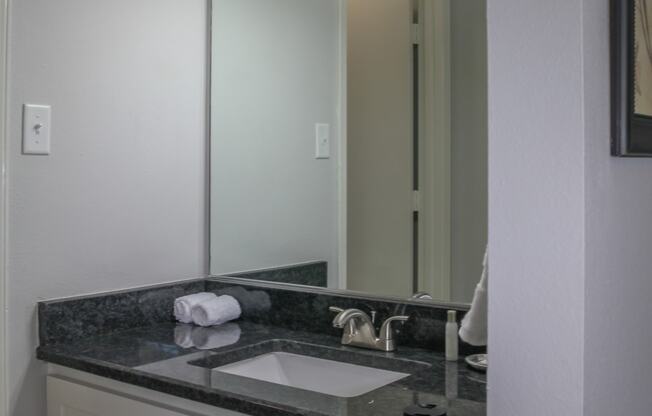 a bathroom with a sink and a mirror at The Village at Cottonwood Springs, El Paso, 79934  