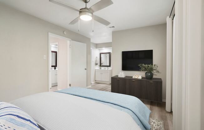 a bedroom with a large bed and a ceiling fan