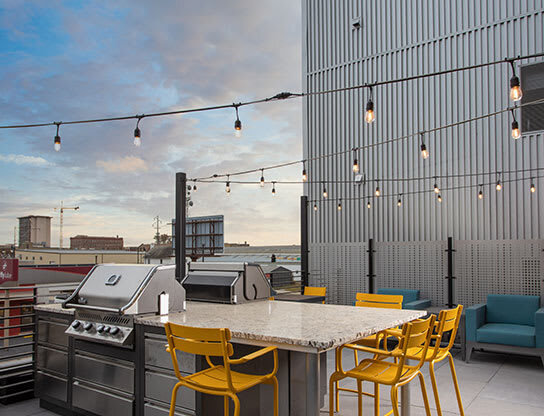 a patio with a table and chairs and a grill at The Landing at 1001 NP, Fargo, ND, 58102