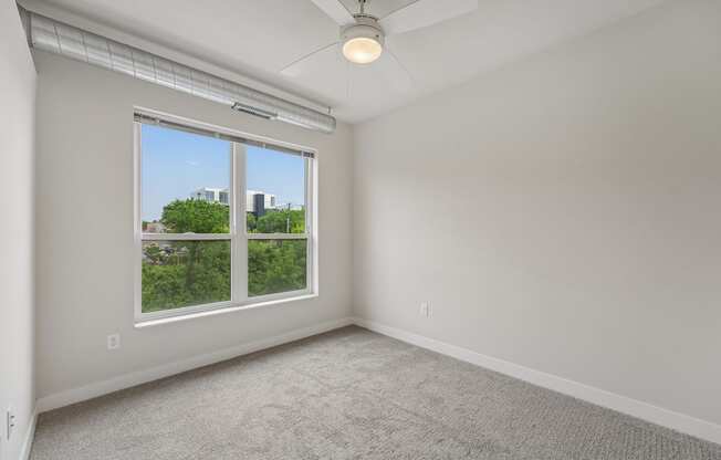 A room with a window and a ceiling fan.