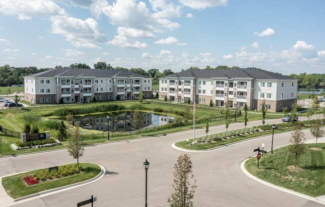 SKy view of Stone Ridge of Shelby Community. Pond in center of community, green grass and paved roads throughout.