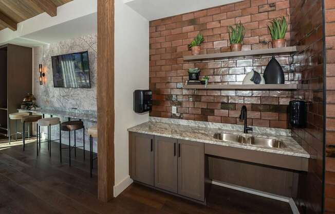 A kitchen with a brick wall and a marble countertop.