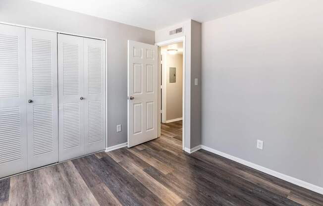 an empty room with two closets and a door to a hallway