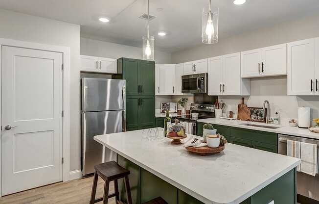 a kitchen with green and white cabinets and a white counter top at Edgebrook Residences, New Hampshire