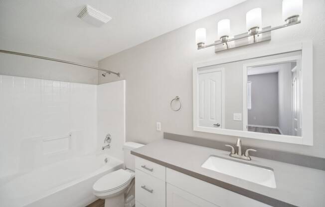 a bathroom with a sink and a tub and a mirror