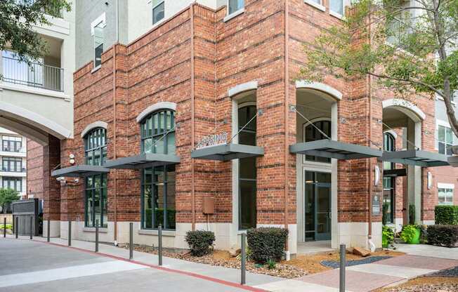 A red brick building with a black awning and a white sign that says