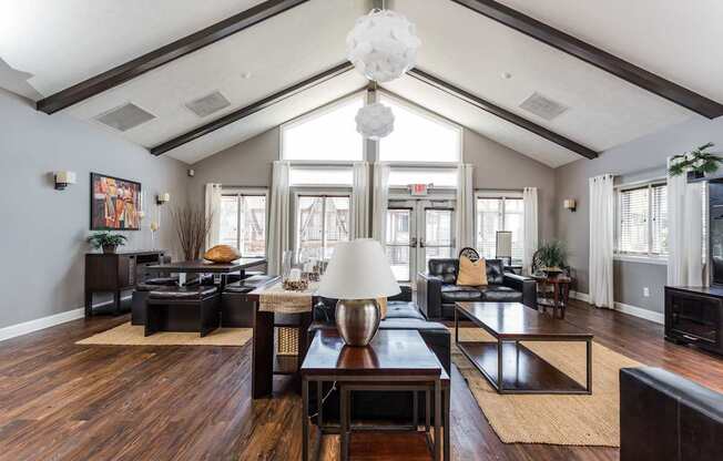 A living room with a wooden floor and a large chandelier.