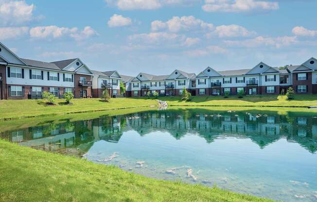 A row of houses with a pond in front.