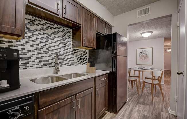 a kitchen with dark wood cabinets and a stainless steel refrigerator