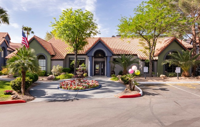 the front of a house with a driveway and trees and plants