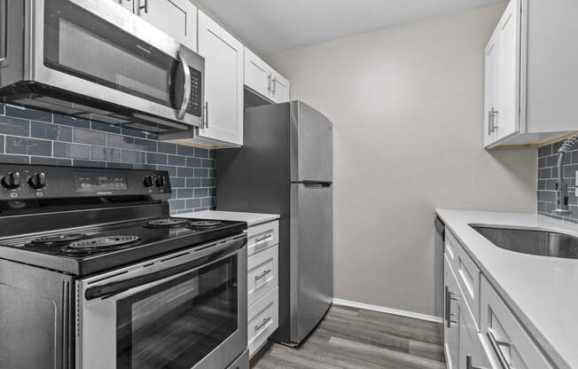 a kitchen with stainless steel appliances and white cabinets